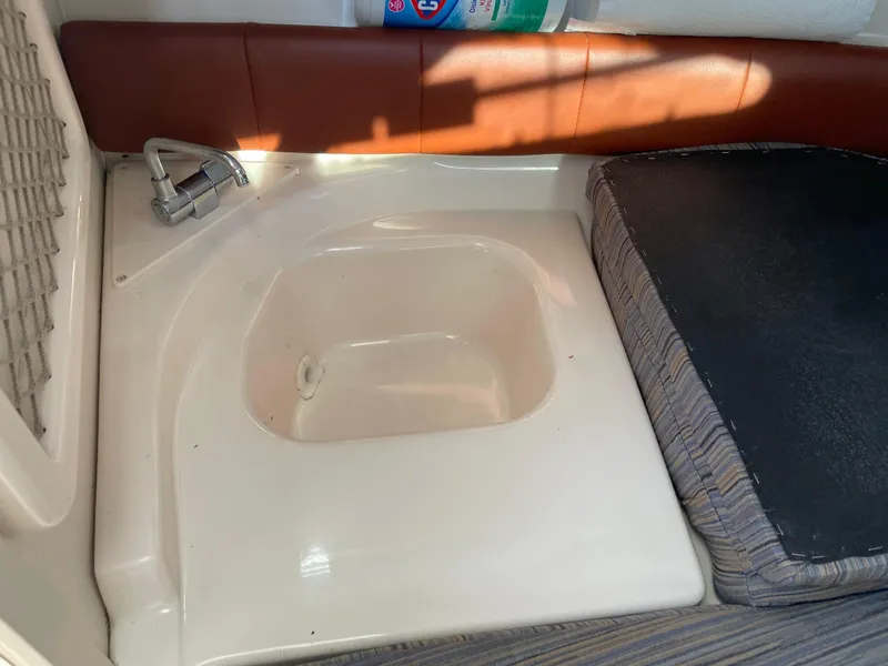 Slide: The Image of 2015 Grady-White Seafarer 226 cabin sink and seating area. - 17