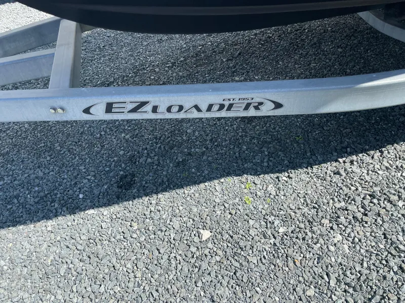 Slide: The Image of EZ Loader trailer for 2015 Grady-White Seafarer 226 on gravel surface. - 23