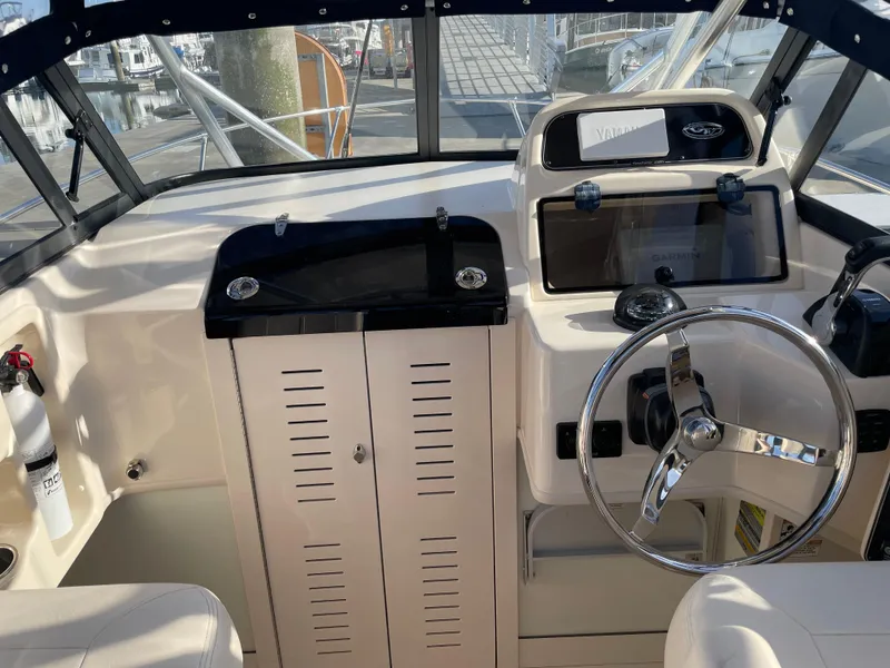 Slide: The Image of 2015 Grady-White Seafarer 226 boat helm with steering wheel and control panel. - 6