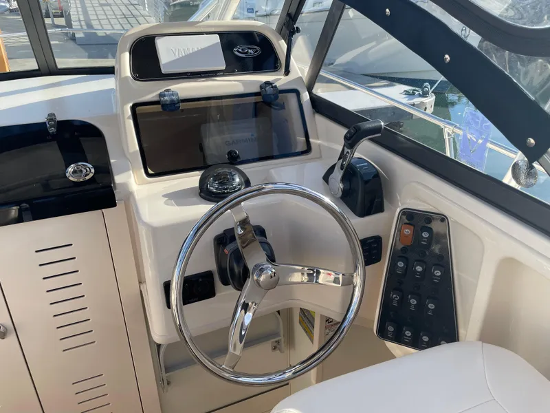 Slide: The Image of 2015 Grady-White Seafarer 226 boat helm with steering wheel and control panel. - 7