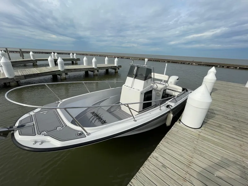 Slide: The Image of 1996 Boston Whaler 21 Outrage docked at a marina under cloudy skies. - 2