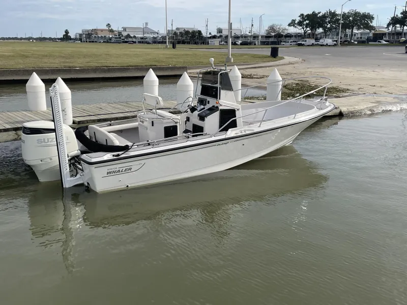 Slide: The Image of 1996 Boston Whaler 21 Outrage boat docked with Suzuki outboard motor. - 4