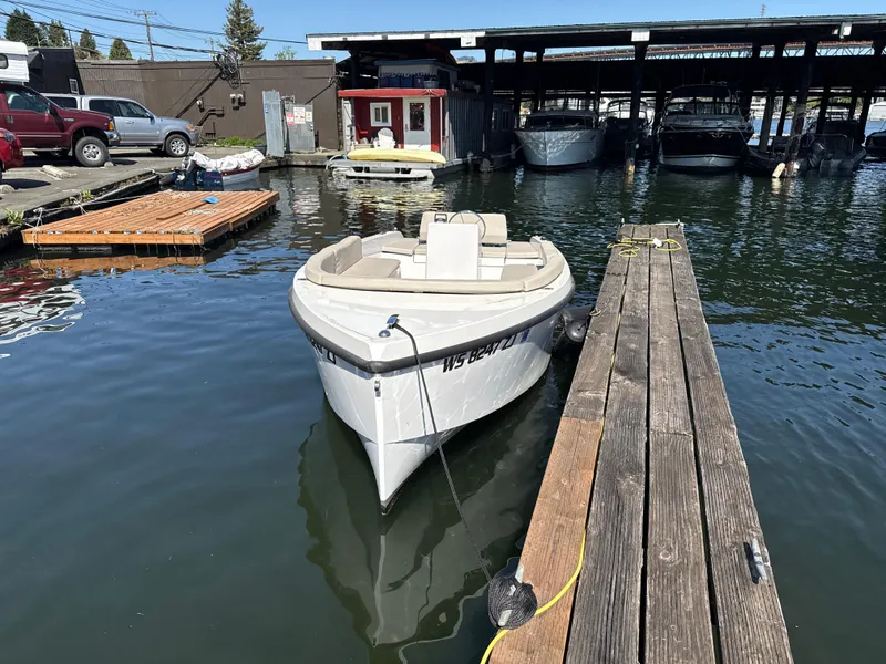 Slide: The Image of A 2022 Rand Picnic boat docked at a marina with surrounding boats. - 11