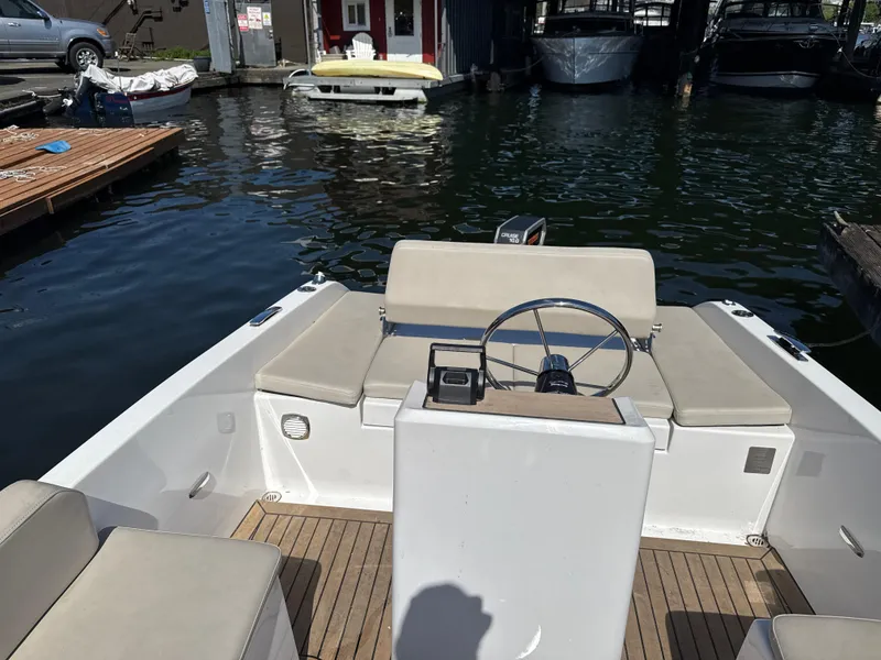 Slide: The Image of 2022 Rand Picnic boat interior with steering wheel, docked at marina. - 4