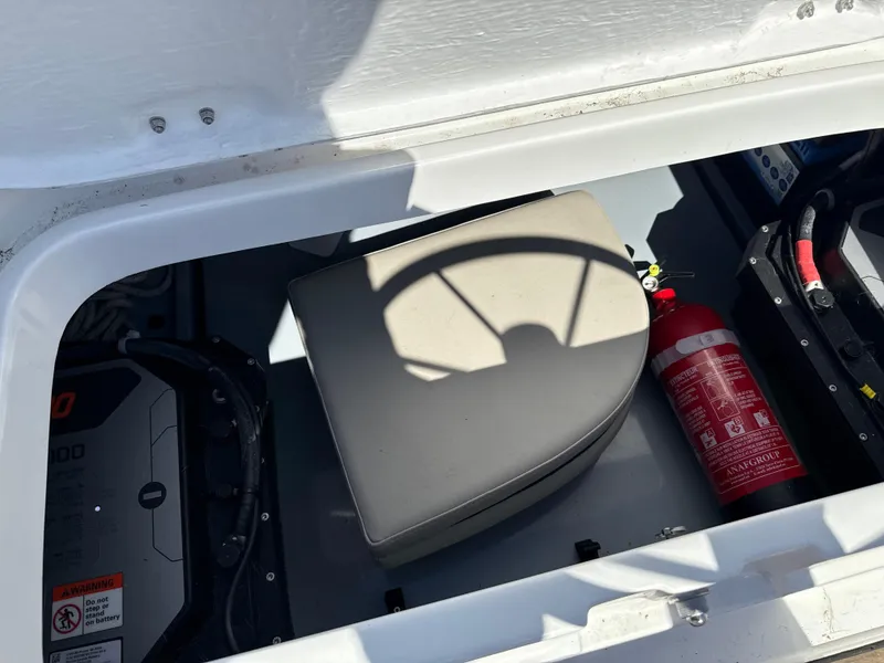 Slide: The Image of Storage compartment in a 2022 Rand Picnic boat with a fire extinguisher and equipment. - 5