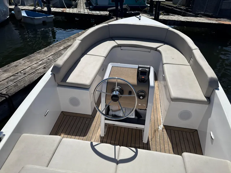 Slide: The Image of 2022 Rand Picnic boat interior with steering wheel and cushioned seating. - 8