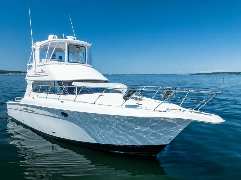 Slide: The Image of 2006 Silverton 42 Convertible yacht cruising on open water under clear blue skies. - 1