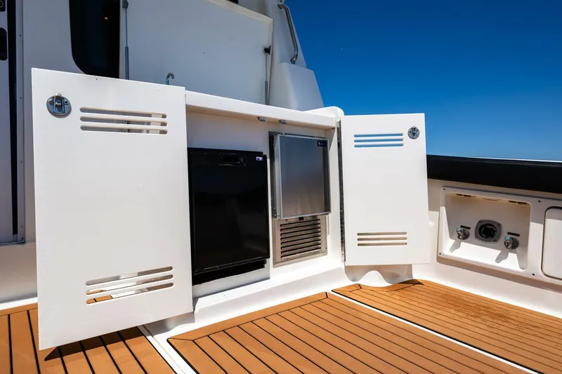 Slide: The Image of 2006 Silverton 42 Convertible yacht deck with storage compartments and wooden flooring. - 10