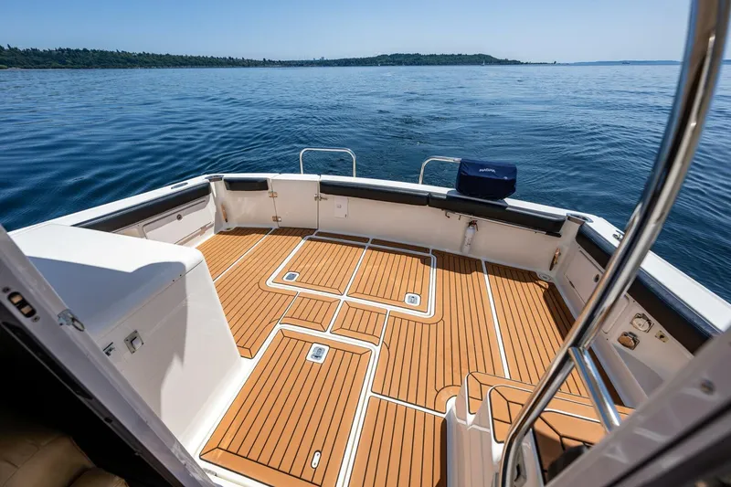 Slide: The Image of 2006 Silverton 42 Convertible boat deck with teak flooring, overlooking calm blue waters. - 11