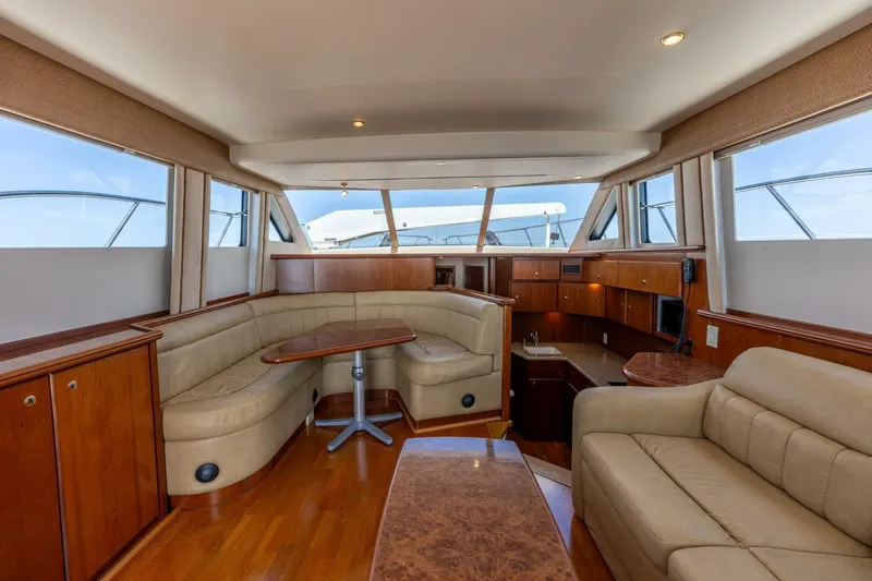 Slide: The Image of Luxurious interior of a 2006 Silverton 42 Convertible yacht with elegant seating and wood finishes. - 12