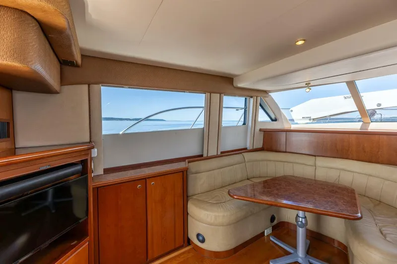 Slide: The Image of Interior of 2006 Silverton 42 Convertible yacht with cozy seating and wooden table. - 14