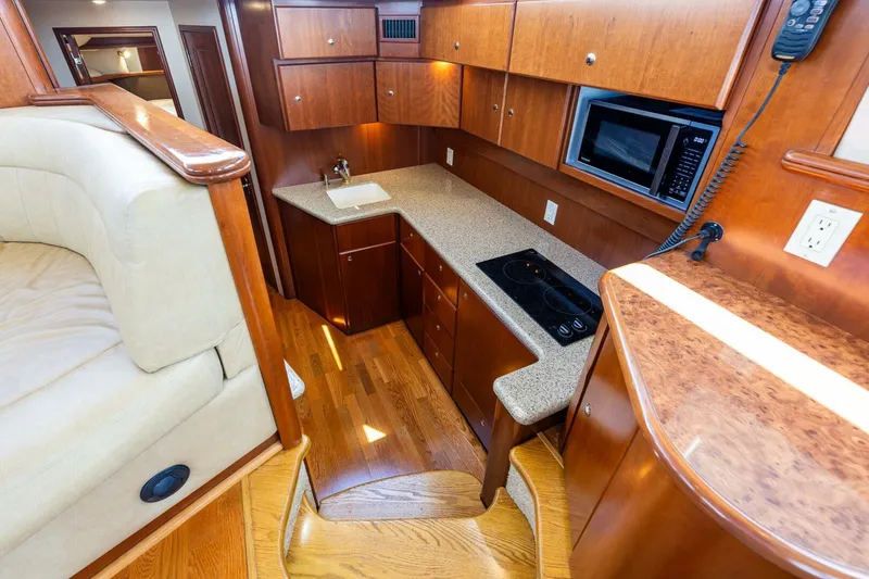 Slide: The Image of Luxurious 2006 Silverton 42 Convertible yacht kitchen with wood cabinetry and modern appliances. - 16