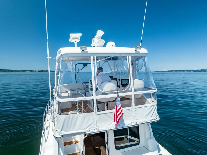Slide: The Image of 2006 Silverton 42 Convertible yacht cruising on calm blue waters under clear skies. - 24