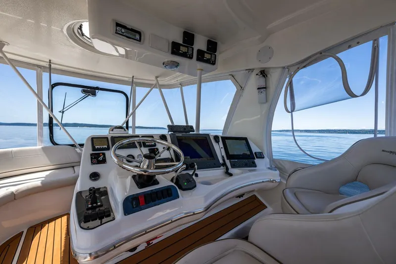 Slide: The Image of Helm of 2006 Silverton 42 Convertible yacht with modern controls and panoramic sea view. - 28