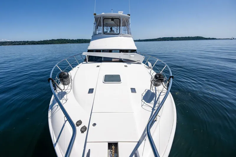 Slide: The Image of 2006 Silverton 42 Convertible yacht on calm water, showcasing sleek design and spacious deck. - 38