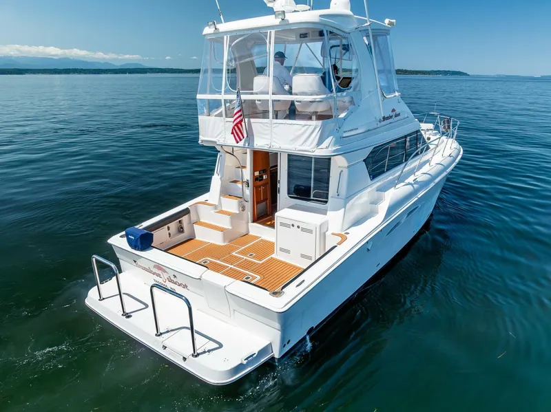 Slide: The Image of 2006 Silverton 42 Convertible yacht on calm water, rear view with American flag. - 4