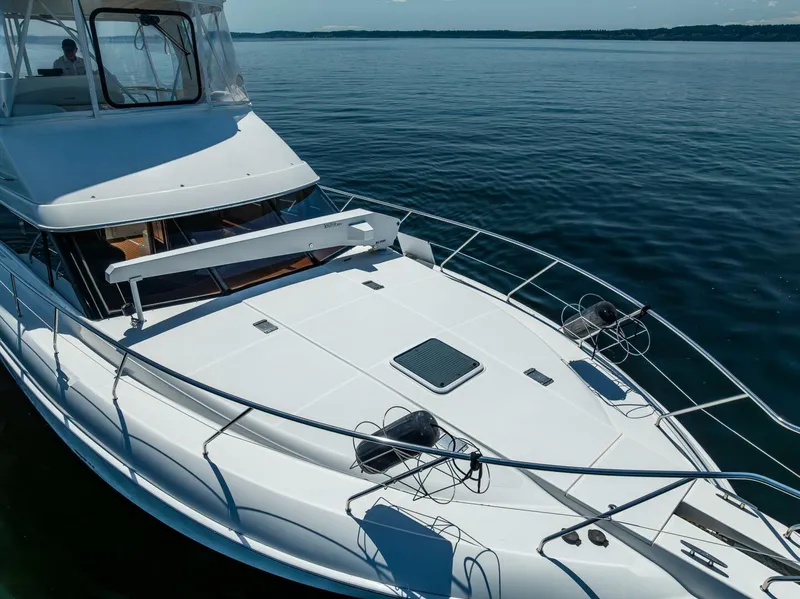 Slide: The Image of 2006 Silverton 42 Convertible yacht on calm water, showcasing sleek design and spacious deck. - 43