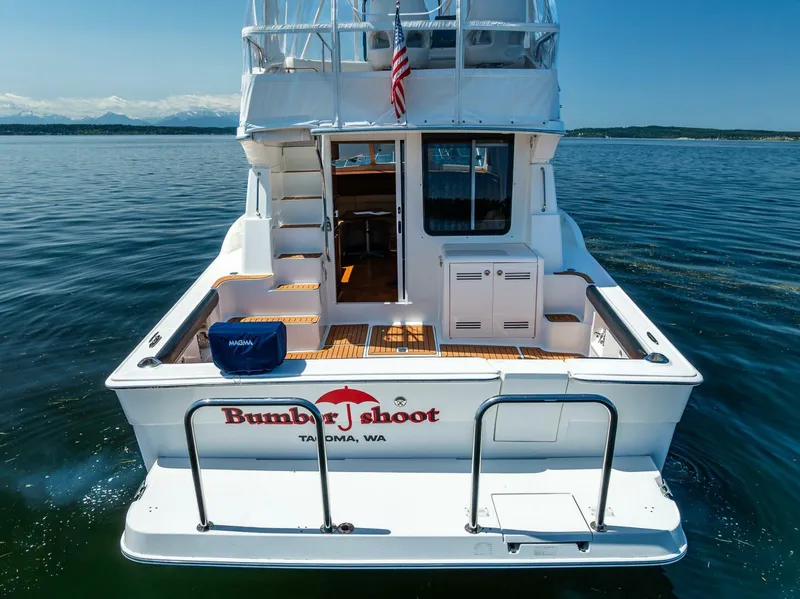 Slide: The Image of 2006 Silverton 42 Convertible yacht on water, rear view, with American flag and Tacoma, WA label. - 5