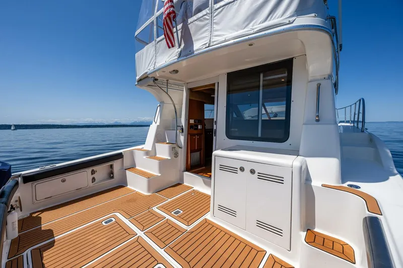 Slide: The Image of 2006 Silverton 42 Convertible yacht with teak deck, docked on calm water. - 6