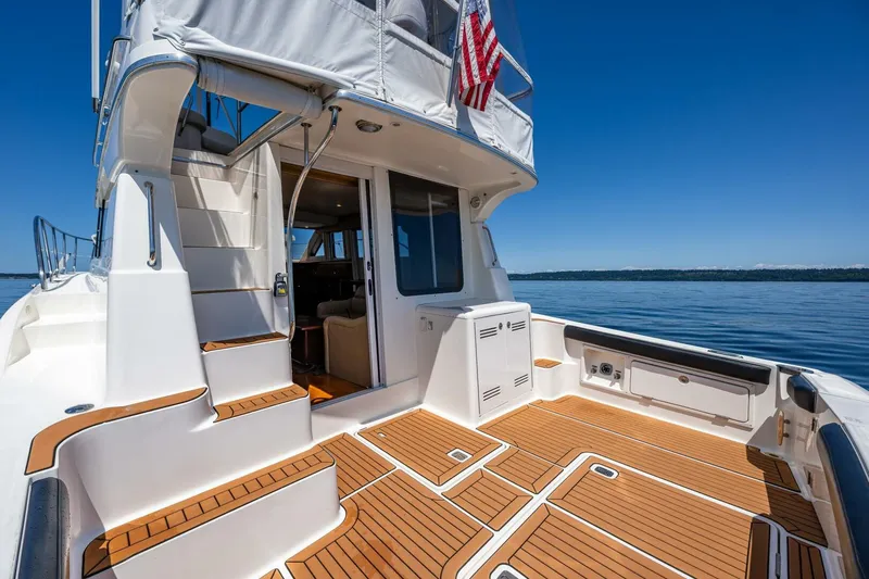 Slide: The Image of 2006 Silverton 42 Convertible yacht deck with teak flooring and American flag. - 7