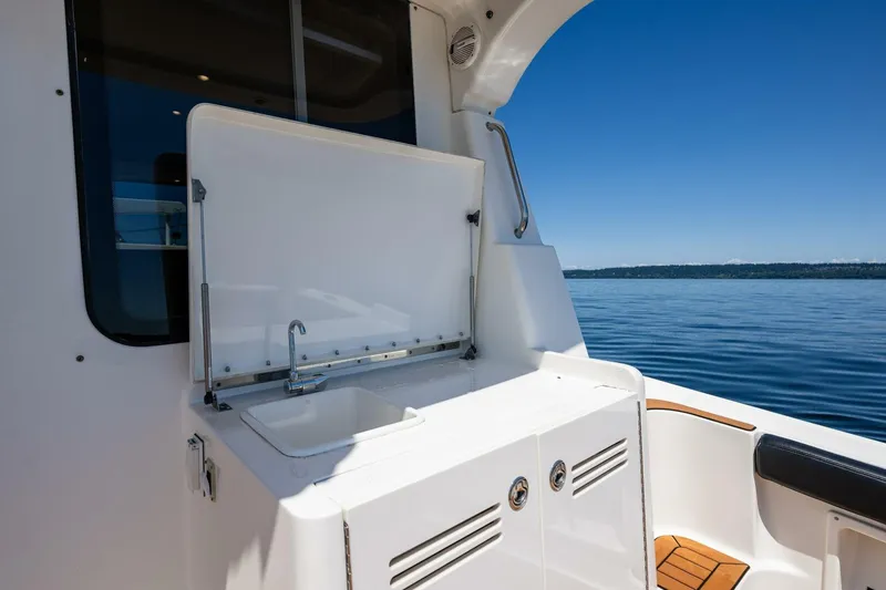 Slide: The Image of 2006 Silverton 42 Convertible yacht with open sink on deck, overlooking calm blue waters. - 9