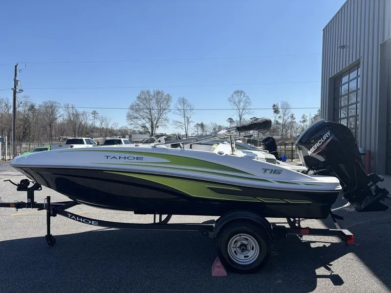 Slide: The Image of 2024 Tahoe T16 boat on trailer, parked outdoors near a building. - 4