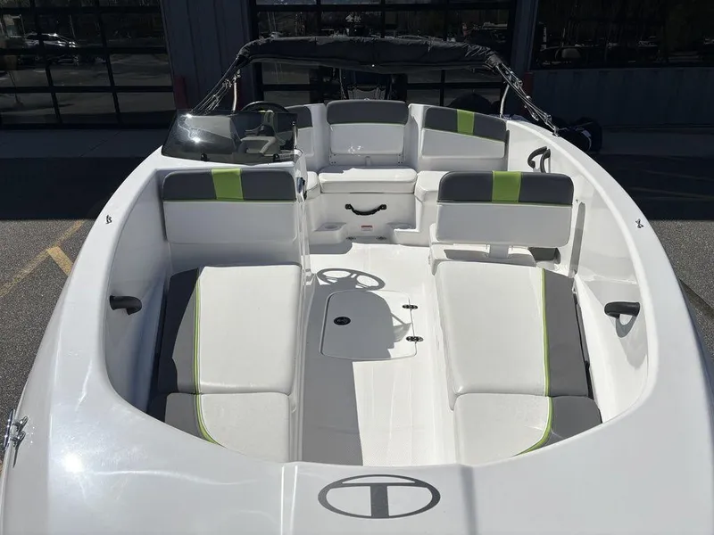 Slide: The Image of 2024 Tahoe T16 boat interior with white and green seating, steering wheel, and open deck. - 8