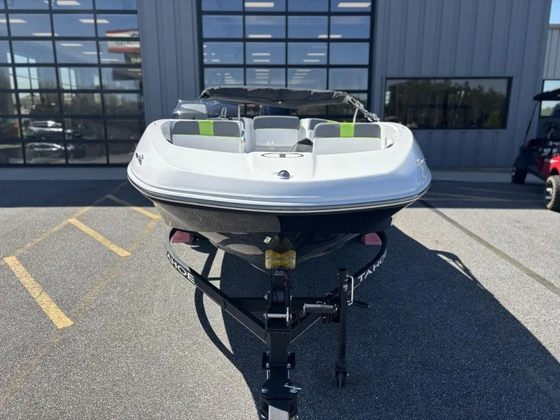 Slide: The Image of 2024 Tahoe T16 boat on trailer, parked outside a modern building. - 9