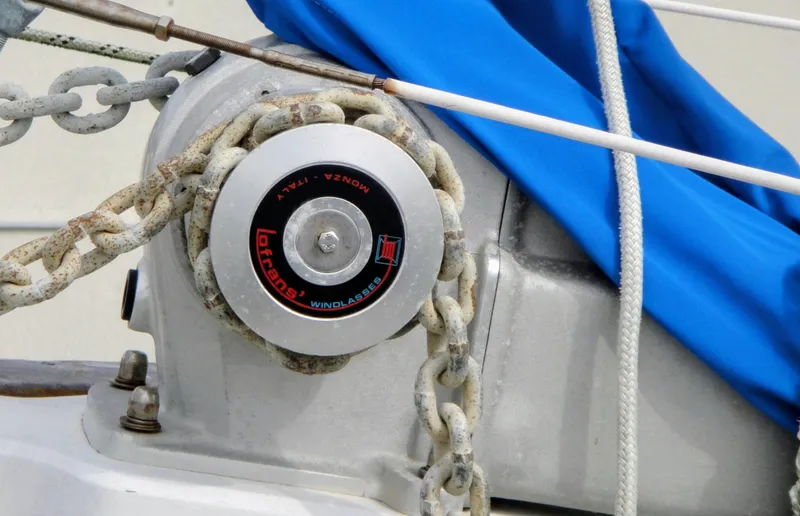 Slide: The Image of 1975 Downeast Ketch windlass with chain and blue cover. - 11