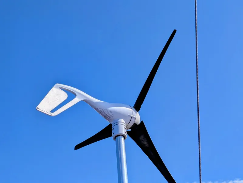 Slide: The Image of Wind turbine on a 1975 Downeast Ketch sailboat against a clear blue sky. - 13