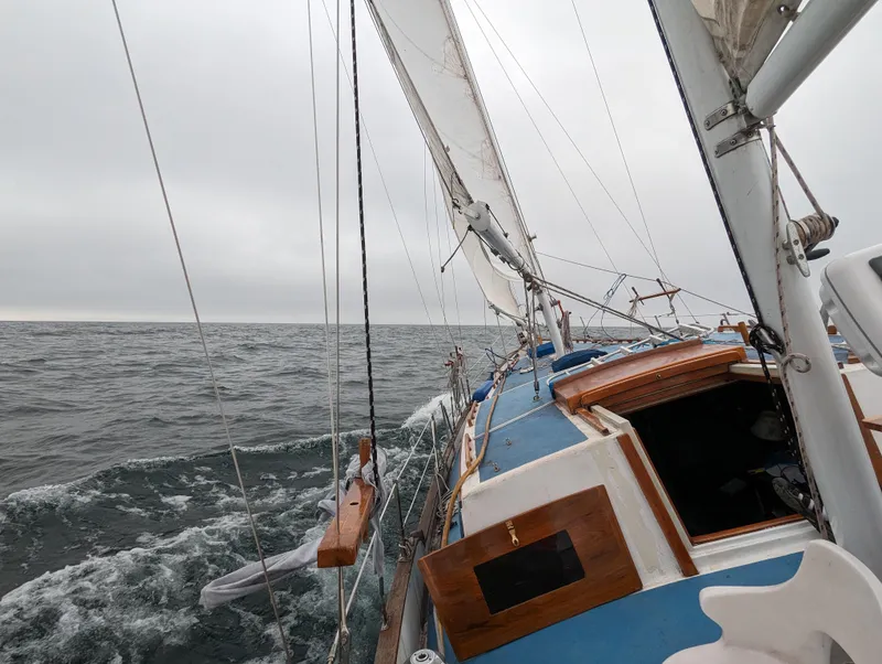 Slide: The Image of 1975 Downeast Ketch sailing on open sea under cloudy skies. - 14