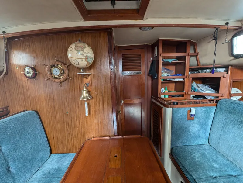 Slide: The Image of Interior of a 1975 Downeast Ketch sailboat with wooden paneling and nautical decor. - 19