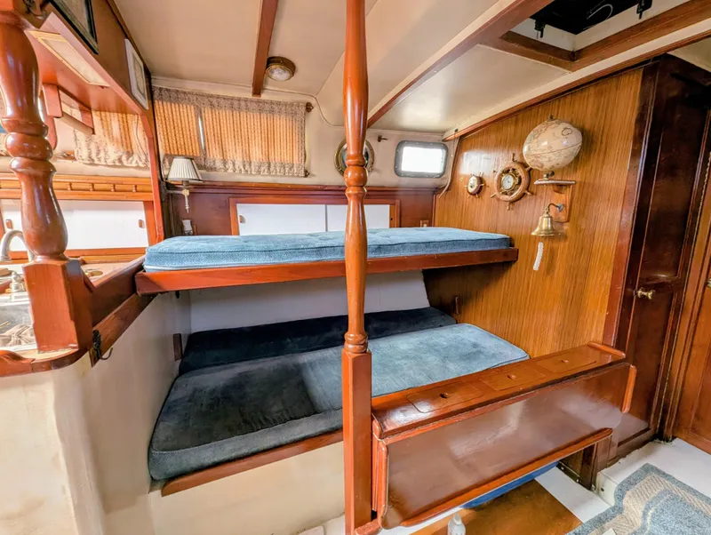 Slide: The Image of 1975 Downeast Ketch interior with wooden bunk beds and nautical decor. - 22