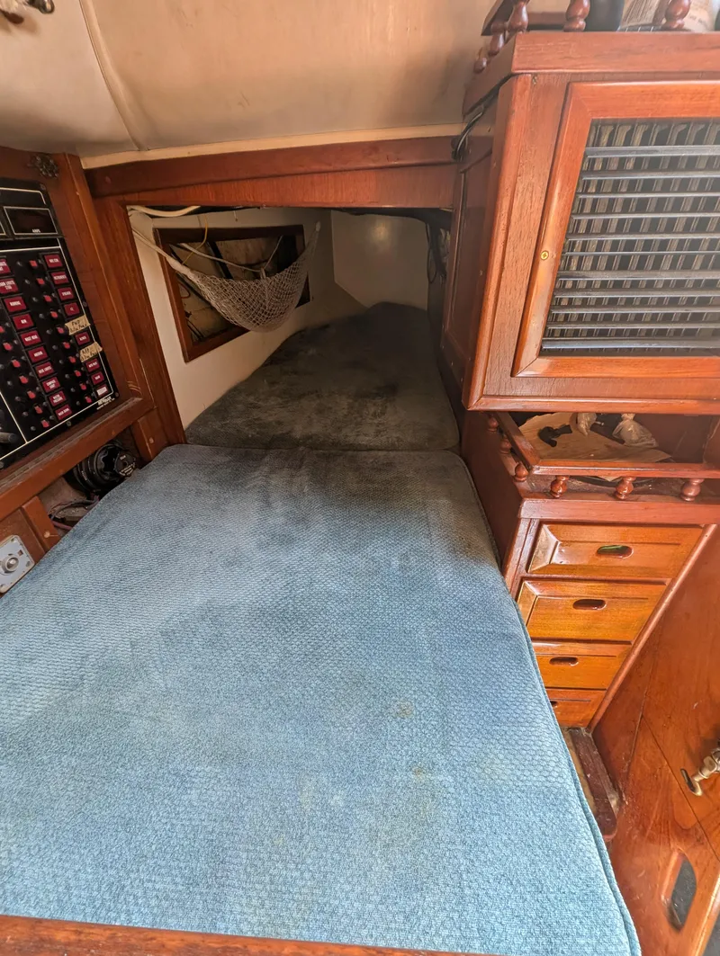 Slide: The Image of 1975 Downeast Ketch interior with cozy sleeping area and wooden cabinetry. - 23