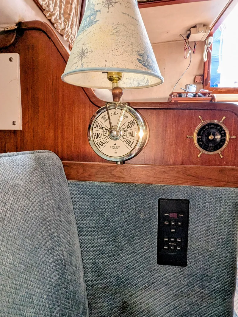 Slide: The Image of 1975 Downeast Ketch interior with barometer, lamp, and nautical decor. - 29