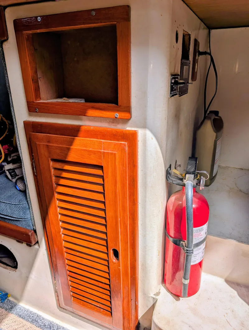 Slide: The Image of 1975 Downeast Ketch interior with wooden cabinet and fire extinguisher. - 35