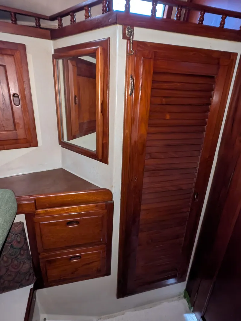 Slide: The Image of 1975 Downeast Ketch interior with wooden cabinets and louvered door. - 41