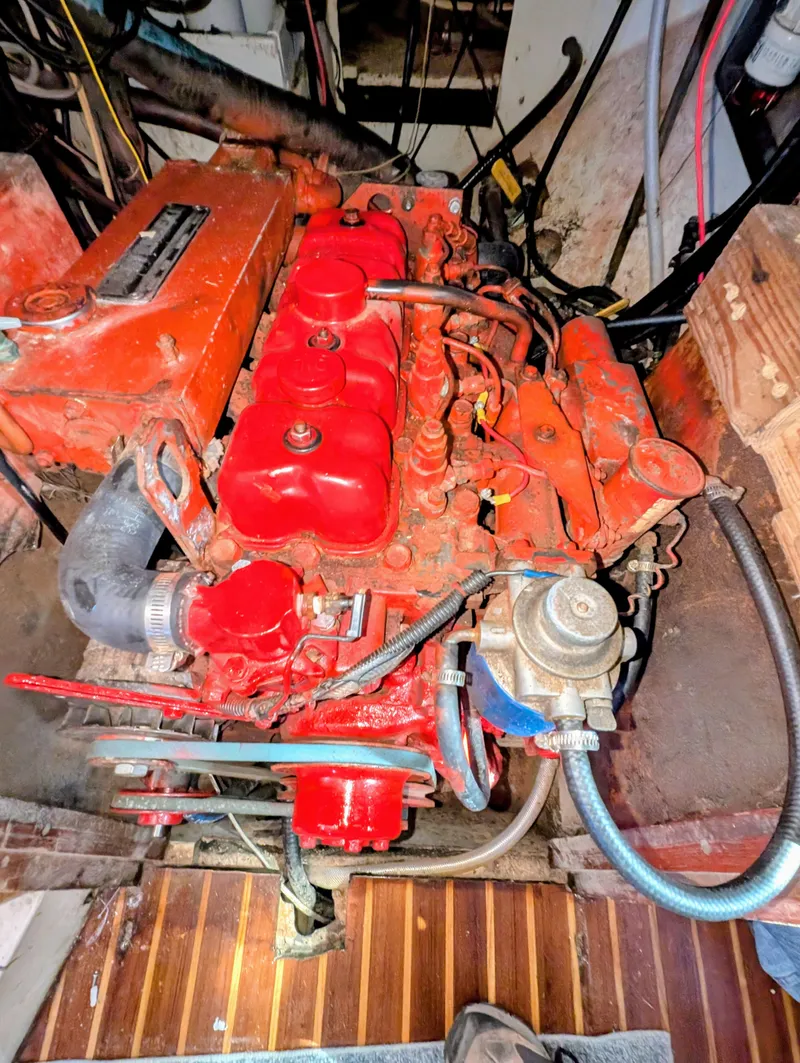 Slide: The Image of 1975 Downeast Ketch engine, vibrant red, detailed view, showcasing mechanical components. - 42
