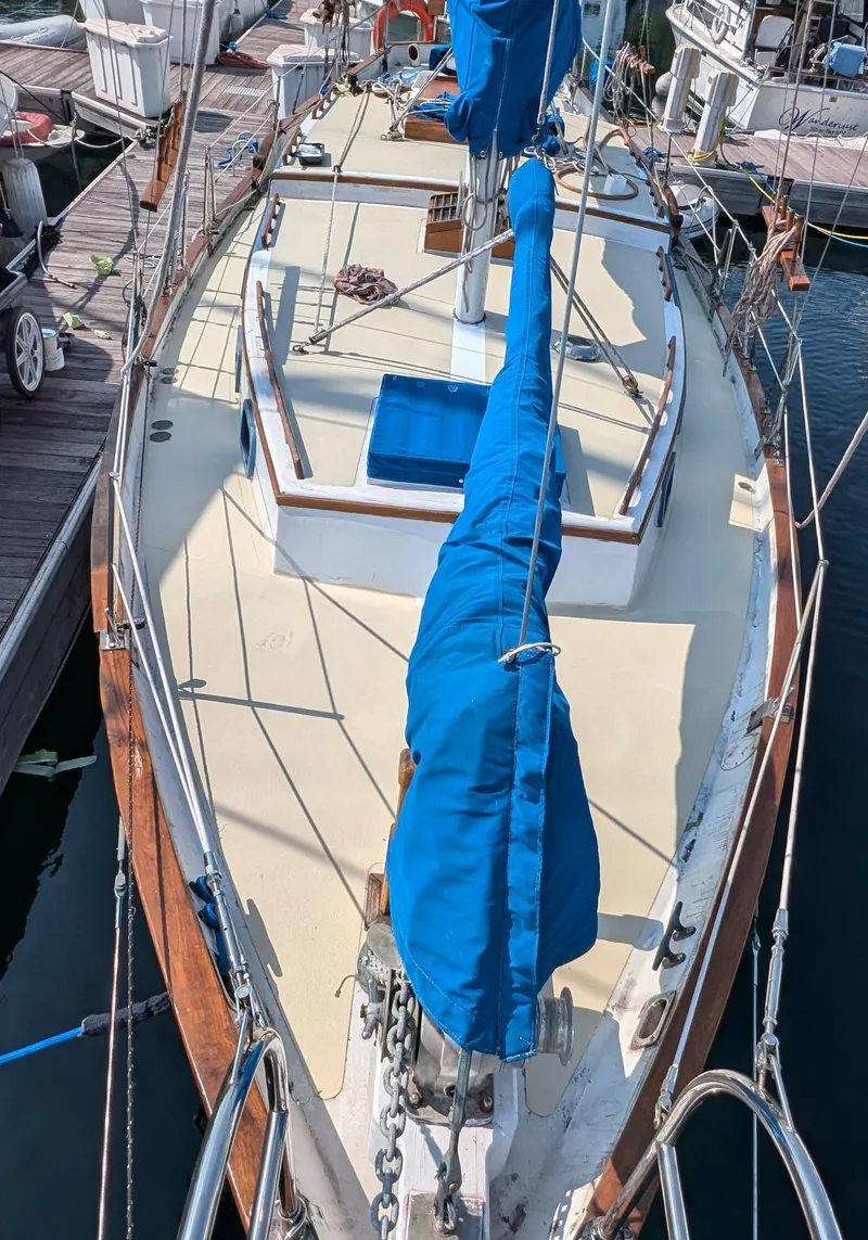 Slide: The Image of 1975 Downeast Ketch sailboat with blue sail cover, docked at marina. - 6