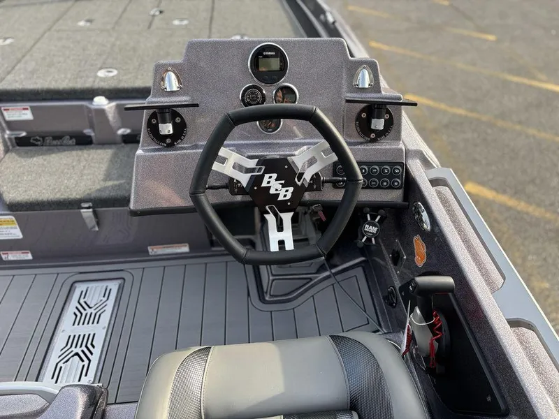 Slide: The Image of 2025 Bass Cat Puma STS boat cockpit with steering wheel and dashboard controls. - 11