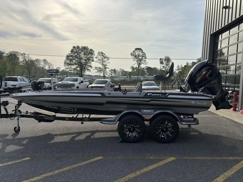 Slide: The Image of 2025 Bass Cat Puma STS boat on trailer, parked outdoors near a building. - 6