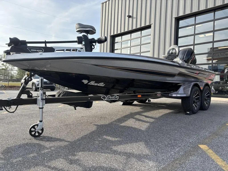 Slide: The Image of 2025 Bass Cat Puma STS boat parked outside a modern garage. - 7