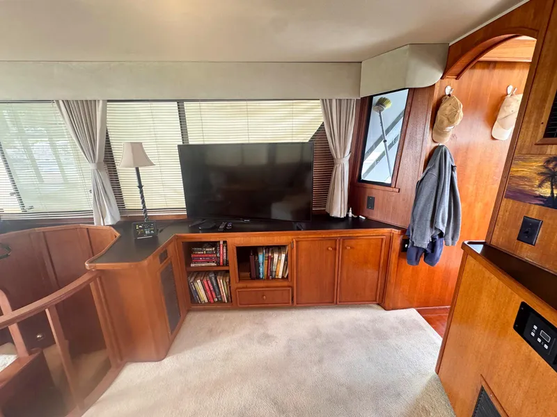 Slide: The Image of Interior of 1988 Chris-Craft 501 Motor Yacht with TV, bookshelves, and wooden cabinetry. - 19