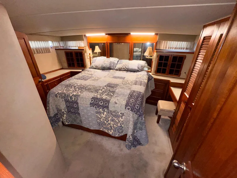 Slide: The Image of 1988 Chris-Craft 501 Motor Yacht bedroom with cozy bed and wooden furnishings. - 20