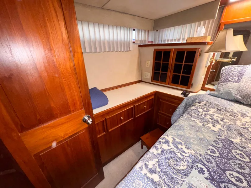 Slide: The Image of Cozy cabin interior of 1988 Chris-Craft 501 Motor Yacht with wood cabinetry and patterned bedding. - 21
