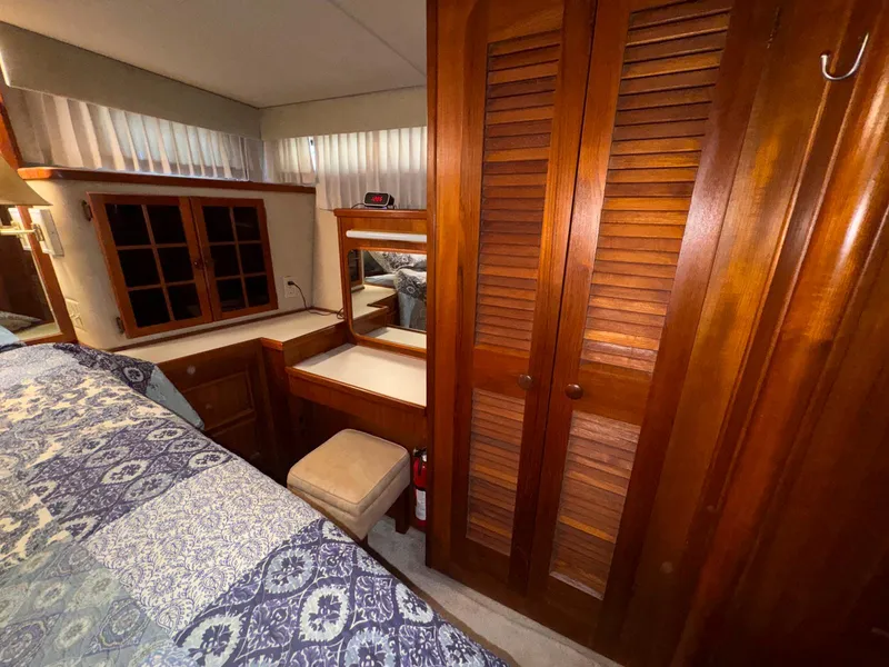 Slide: The Image of Interior of 1988 Chris-Craft 501 Motor Yacht with wooden cabinetry and cozy bedroom. - 22