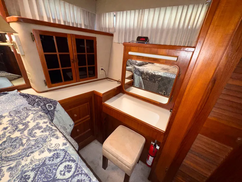 Slide: The Image of 1988 Chris-Craft 501 Motor Yacht interior with wooden vanity, mirror, and stool. - 23