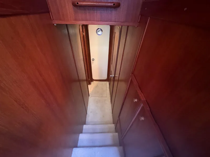 Slide: The Image of Stairway inside 1988 Chris-Craft 501 Motor Yacht with wooden paneling and carpeted steps. - 32