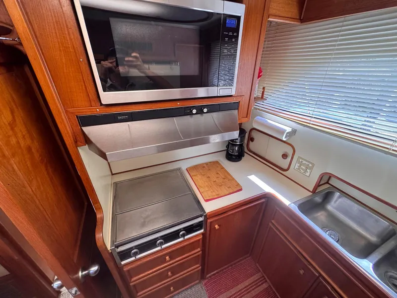 Slide: The Image of 1988 Chris-Craft 501 Motor Yacht kitchen with stove, microwave, and sink. - 36