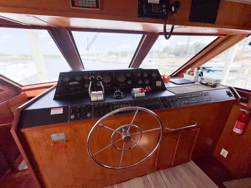 Slide: The Image of 1988 Chris-Craft 501 Motor Yacht helm with steering wheel and control panel. - 44